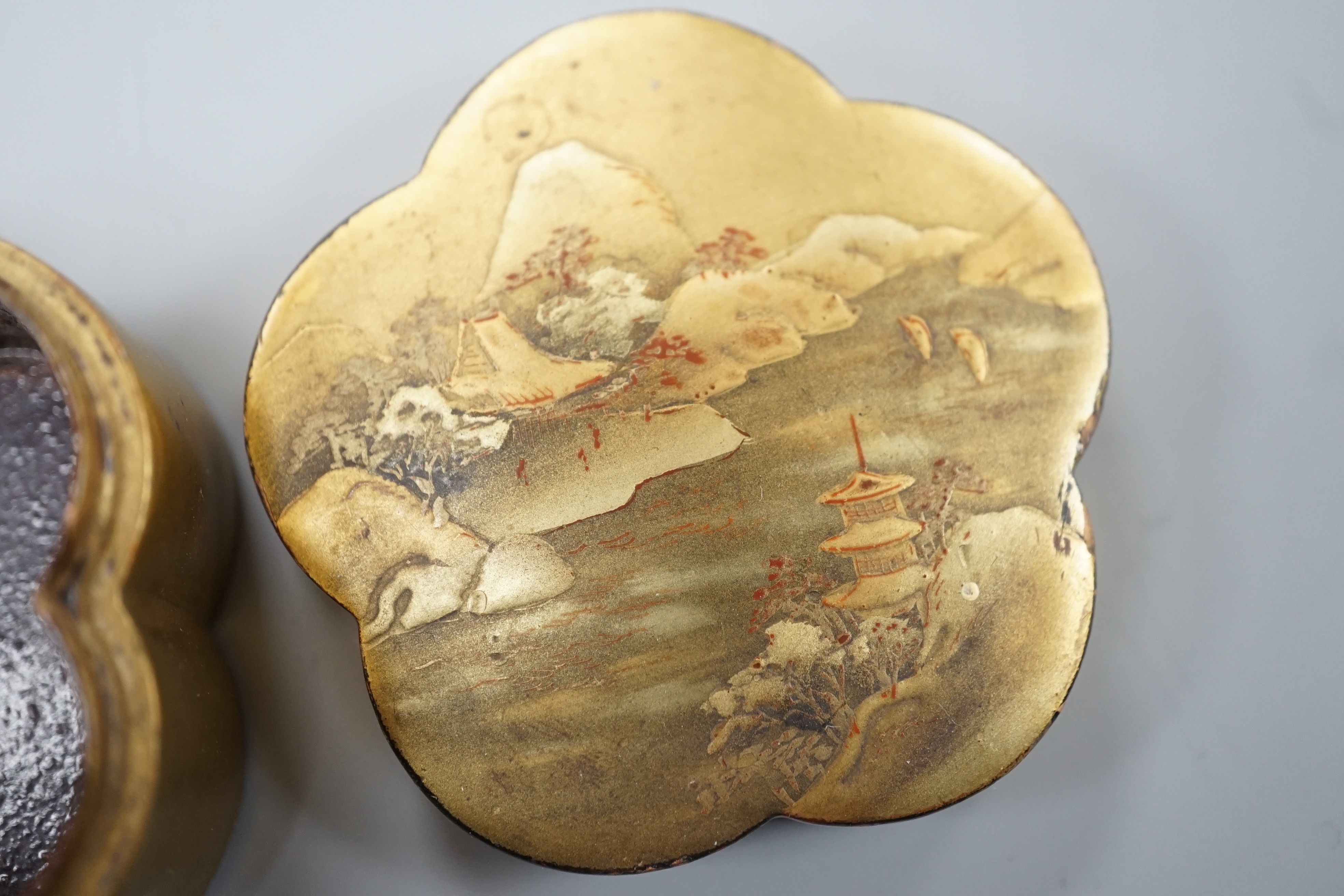 Two Japanese lacquer boxes, an ivory and bronze manju, an ivory ‘lion’ two-piece belt buckle and two simulated ivory items, late 19th/early 20th century, largest Box 11.5 cm